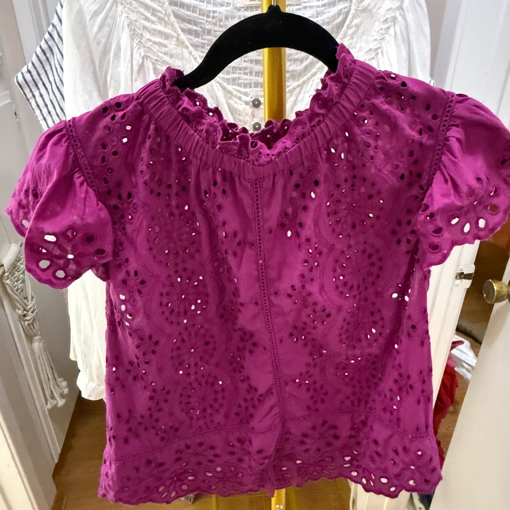 Fuchsia colored top with cut out detail. Bottons on back